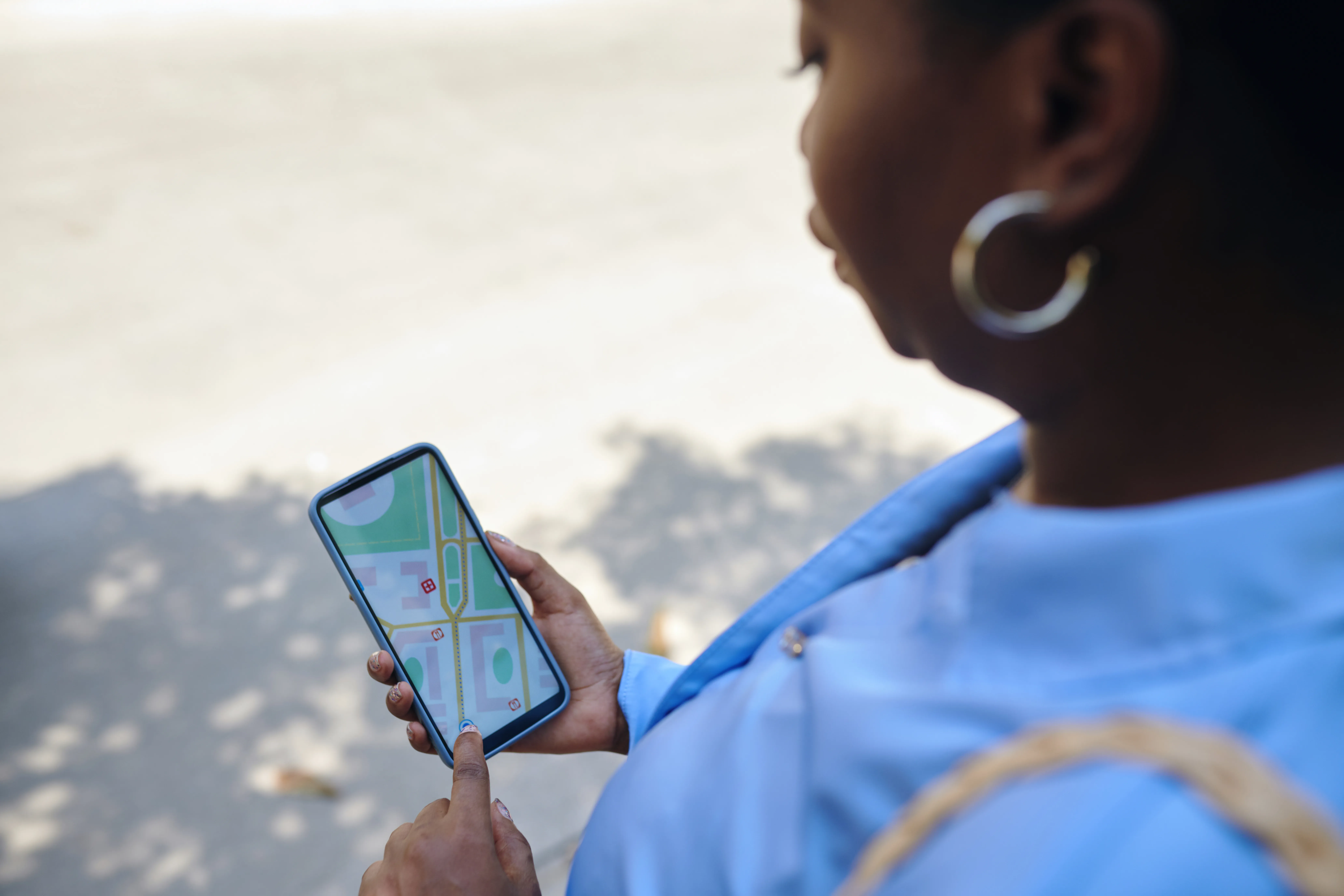 Persona usando un smartphone para navegar un mapa, obteniendo su ubicación precisa vía GPS satelital.